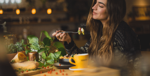 a woman enjoying a salad with a coffee